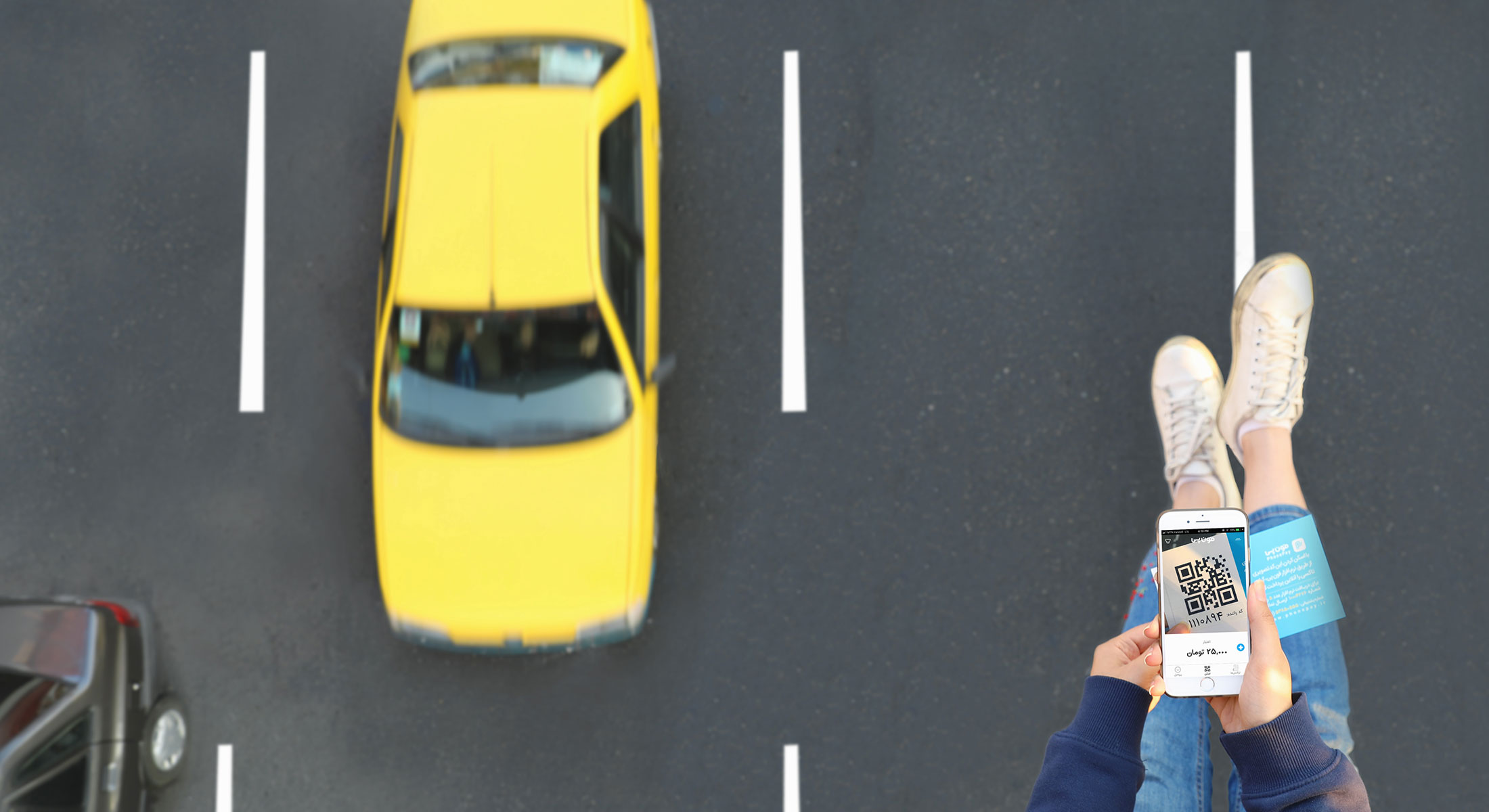 دختری بر بالای اتوبان که تاکسی زردی در تصویر مشاهده می شود اپلیکیشن فونپی را باز کرده